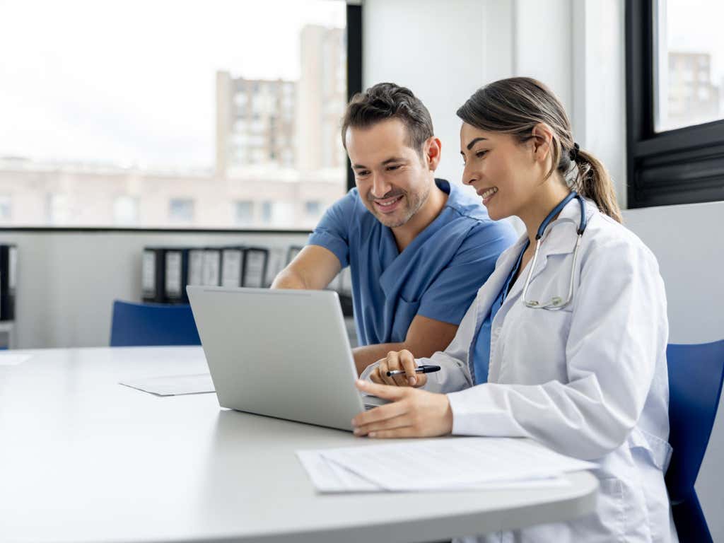 Team of doctors working on a laptop in the meeting room at the hospital.
